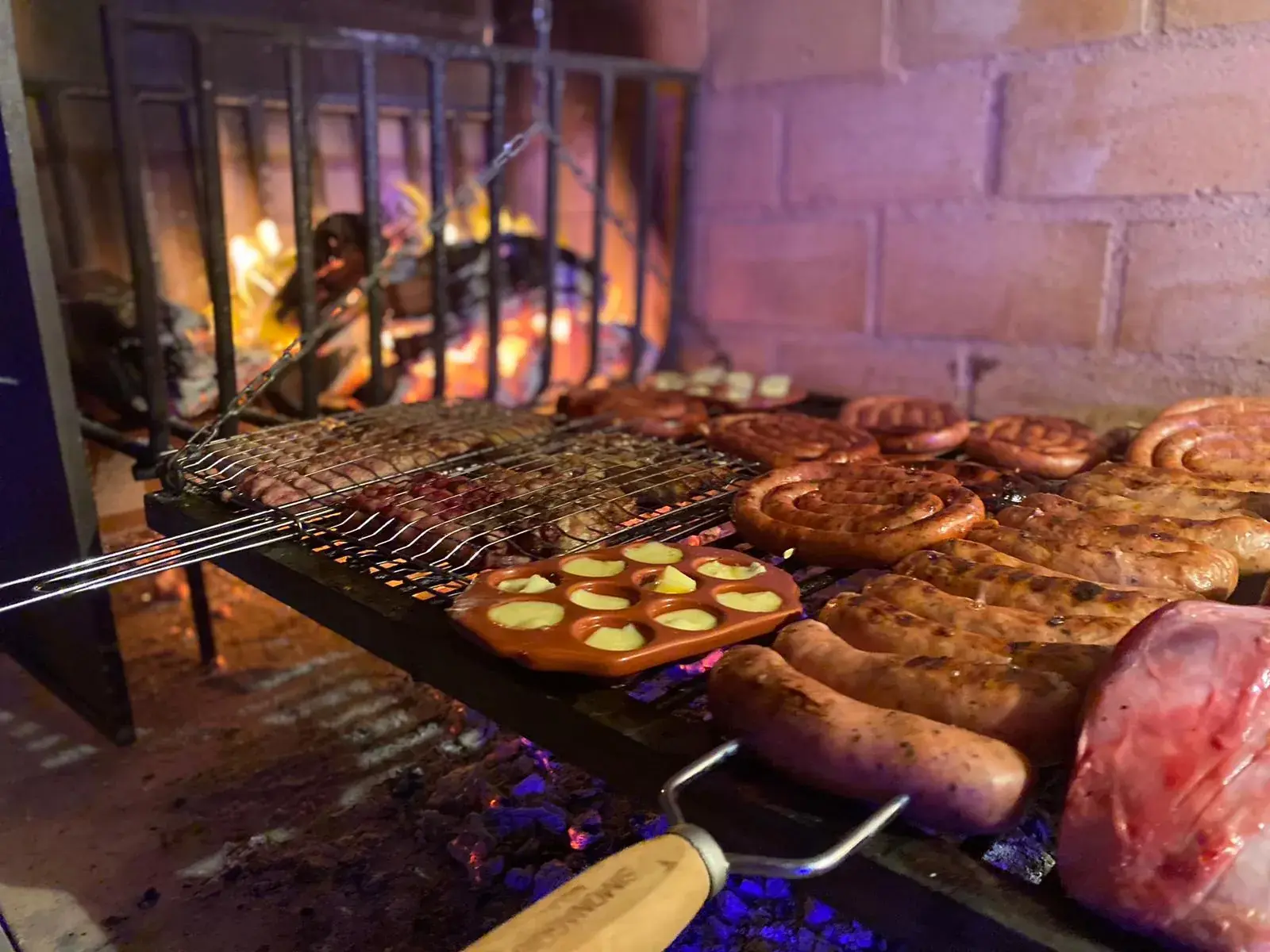 Chorizos y provoleta sobre las brasas de la parrilla